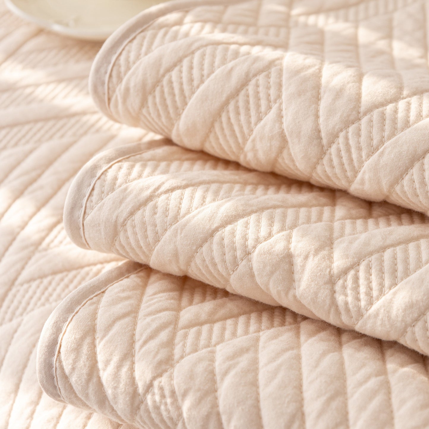 Close-up of Quilted Geometric Cotton Sofa Cover, Non-Slip & Thick Padded Furniture Covers with diagonal stitching and texture.