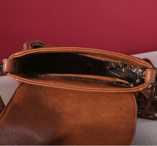 Open view of brown Montana West Fringe Mariposa Concho Collection Crossbody, showcasing spacious interior against red background.