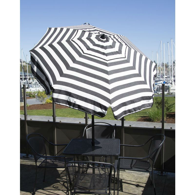 6 Foot Black White Stripe Drape Umbrella Manual Lift with Tilt providing shade on a patio with marina view