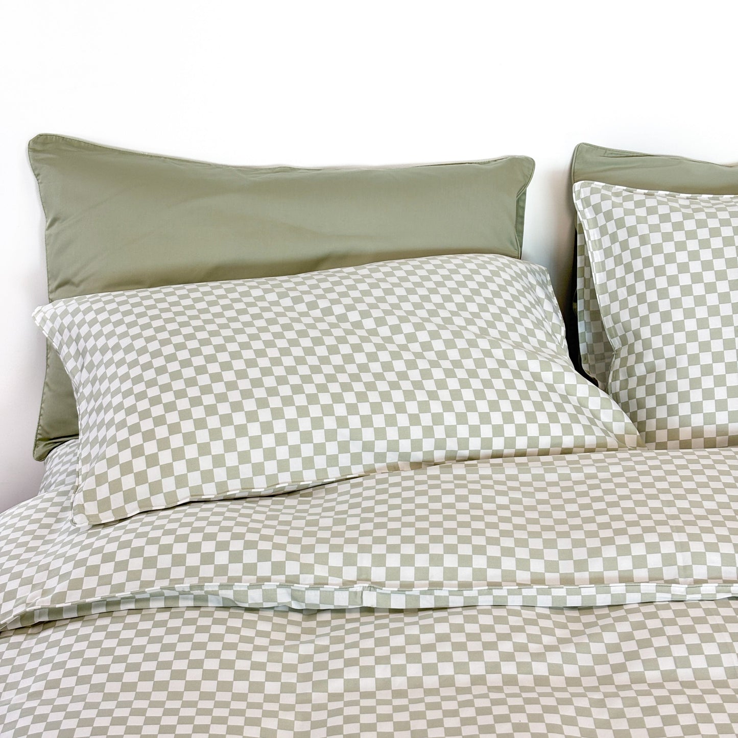 SHNUGGLE Bedding Set Sage Checker on bed with matching pillows, featuring soft 400-thread-count cotton and wrinkle-resistant design.