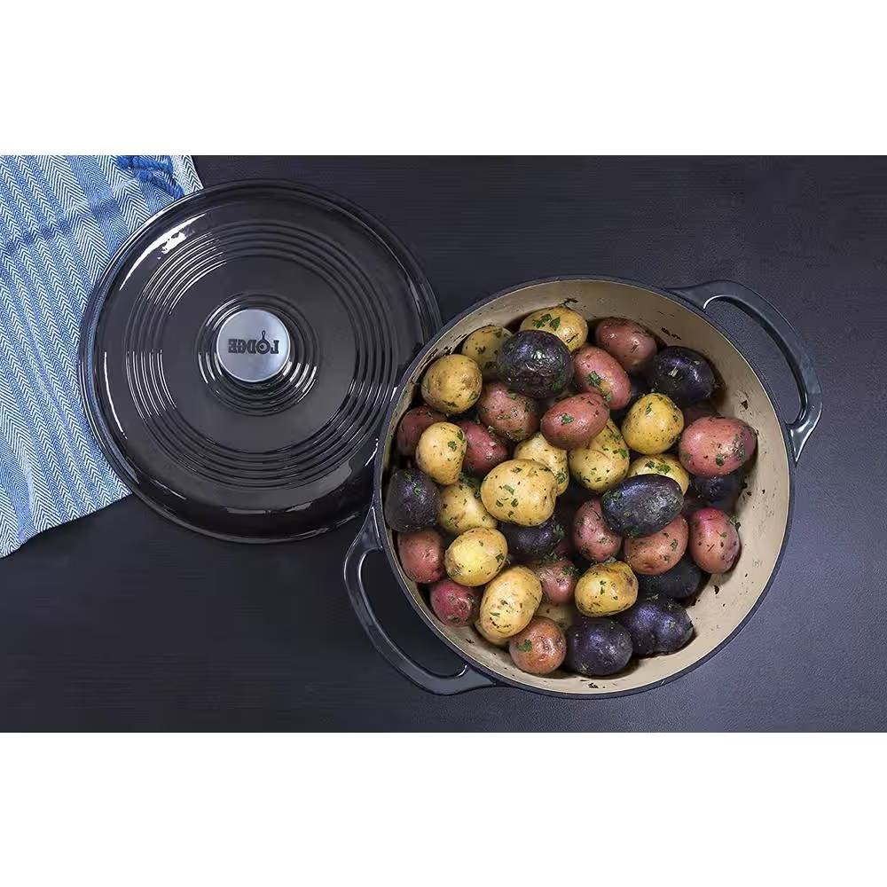 Round 6-Quart Black Enamel Cast Iron Dutch Oven with Lid filled with colorful seasoned potatoes on a dark surface