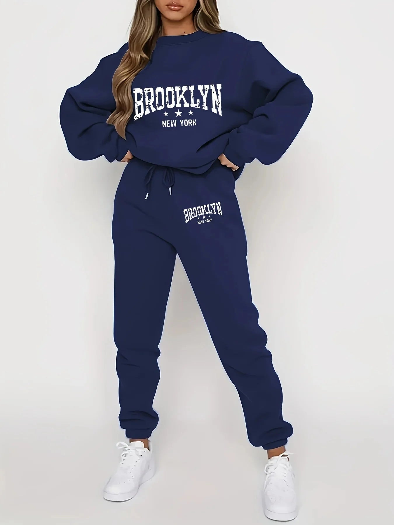 Woman wearing a navy Brooklyn sweatsuit with white sneakers, front view