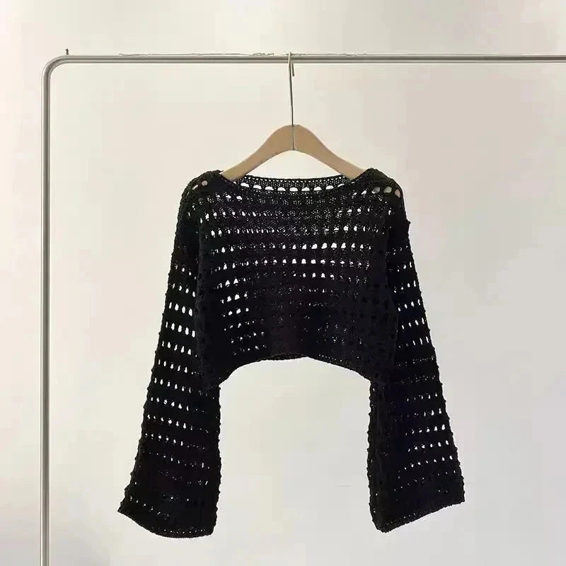 Women’s crochet knit beach cover up in black, long sleeve crochet knit top, perfect for summer, boho chic style, on a hanger.
