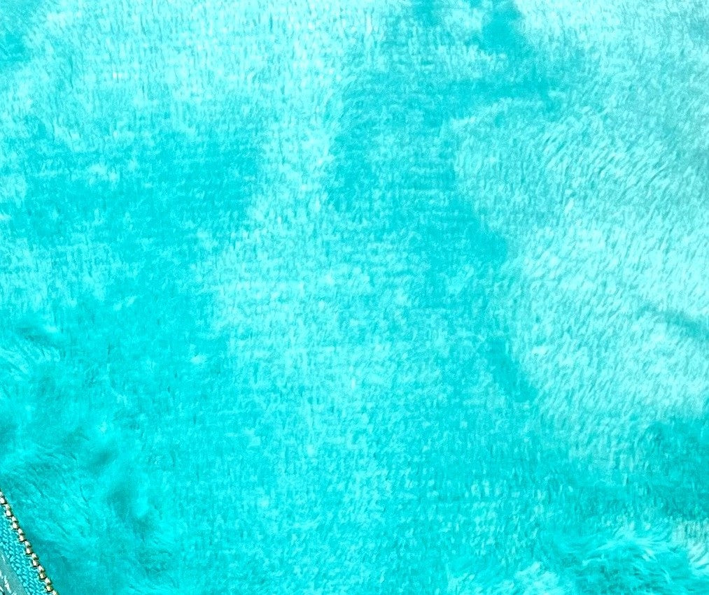 Close-up of ultra-soft flannel fabric of a Golf / Travel Blanket, featuring plush texture and vibrant turquoise color for cozy warmth.