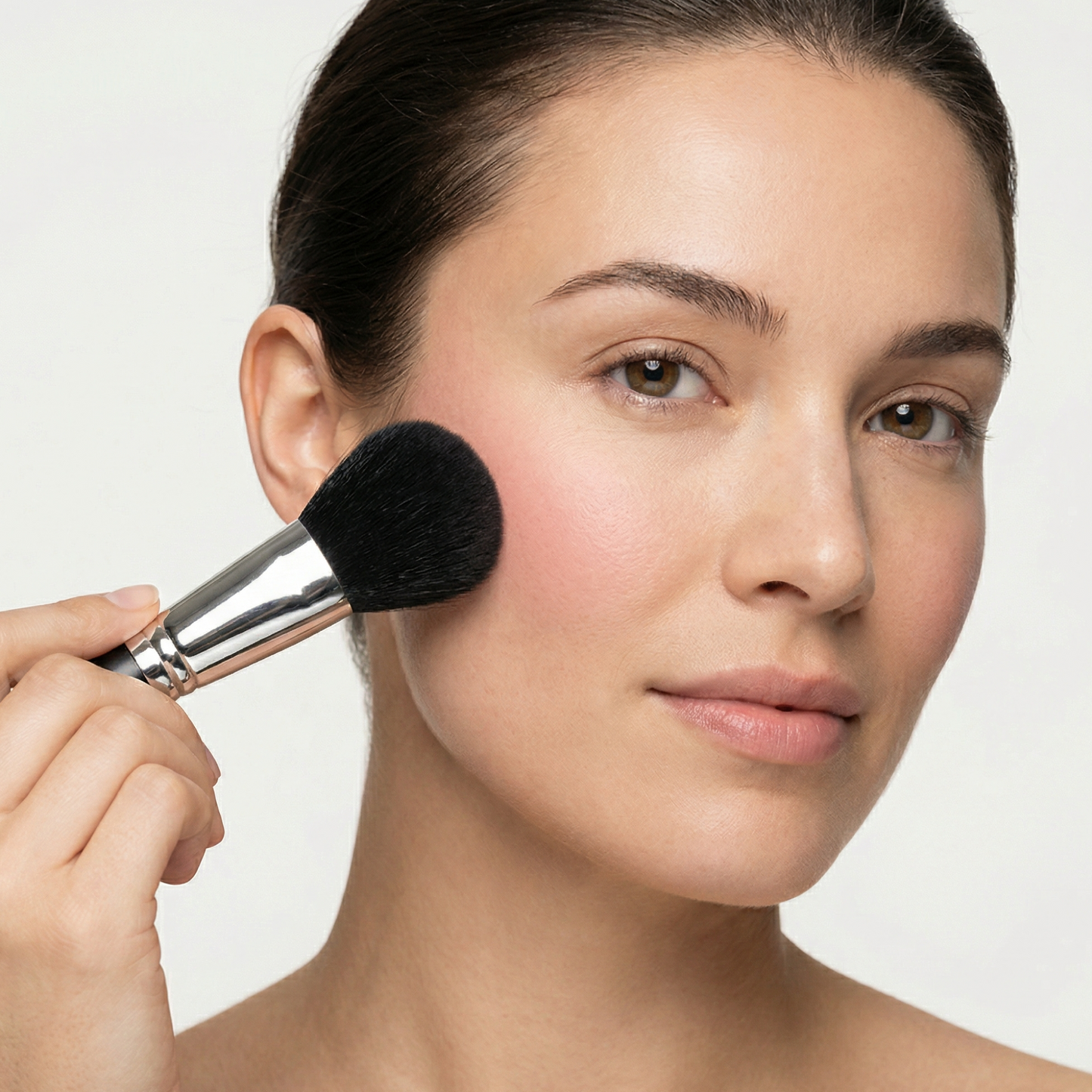 Woman applying makeup with Velvet Brush for airbrushed finish