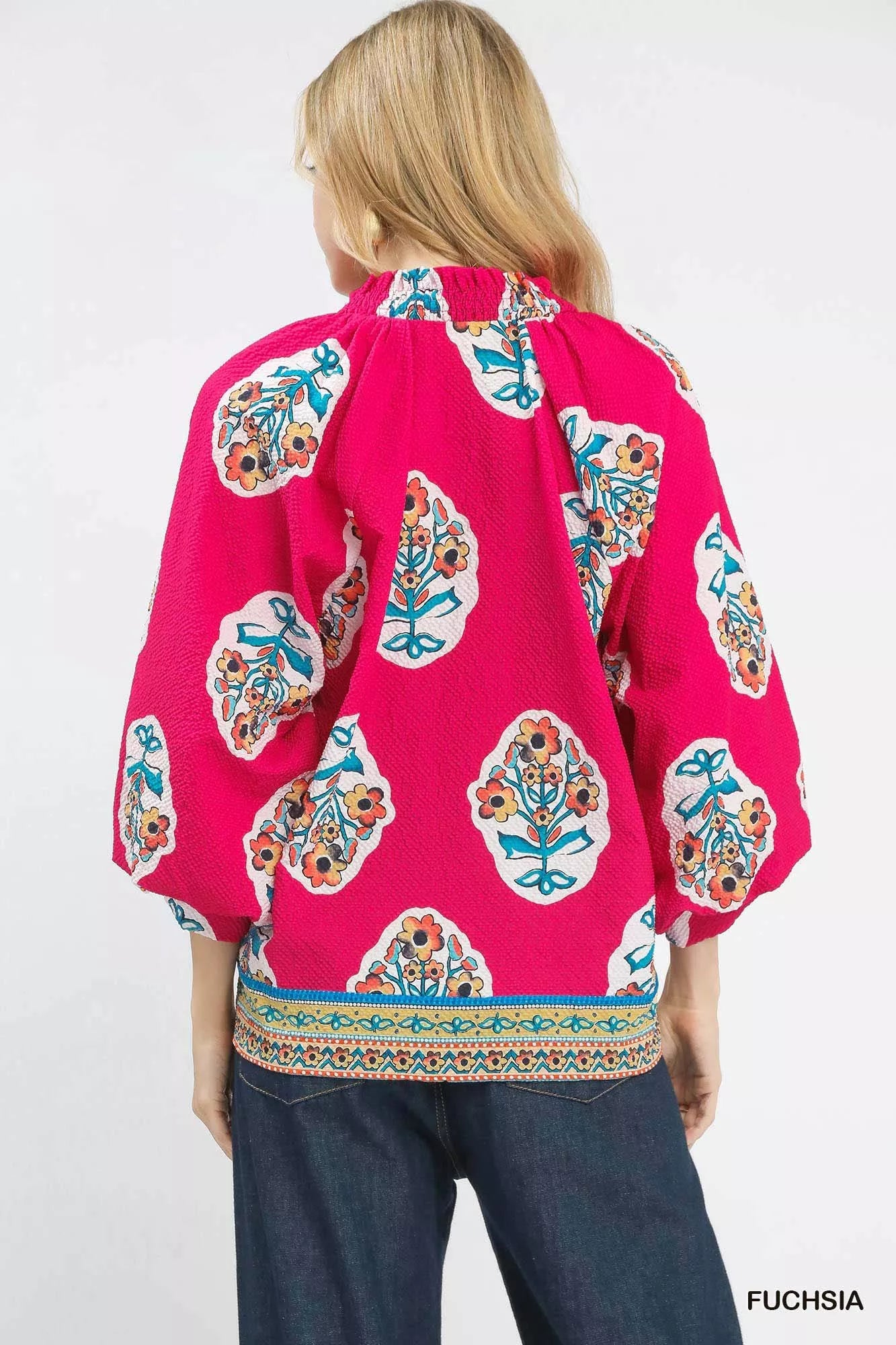 Back view of the Umgee Boho Floral Print Tunic Blouse in fuchsia with vibrant pattern and wide sleeves.