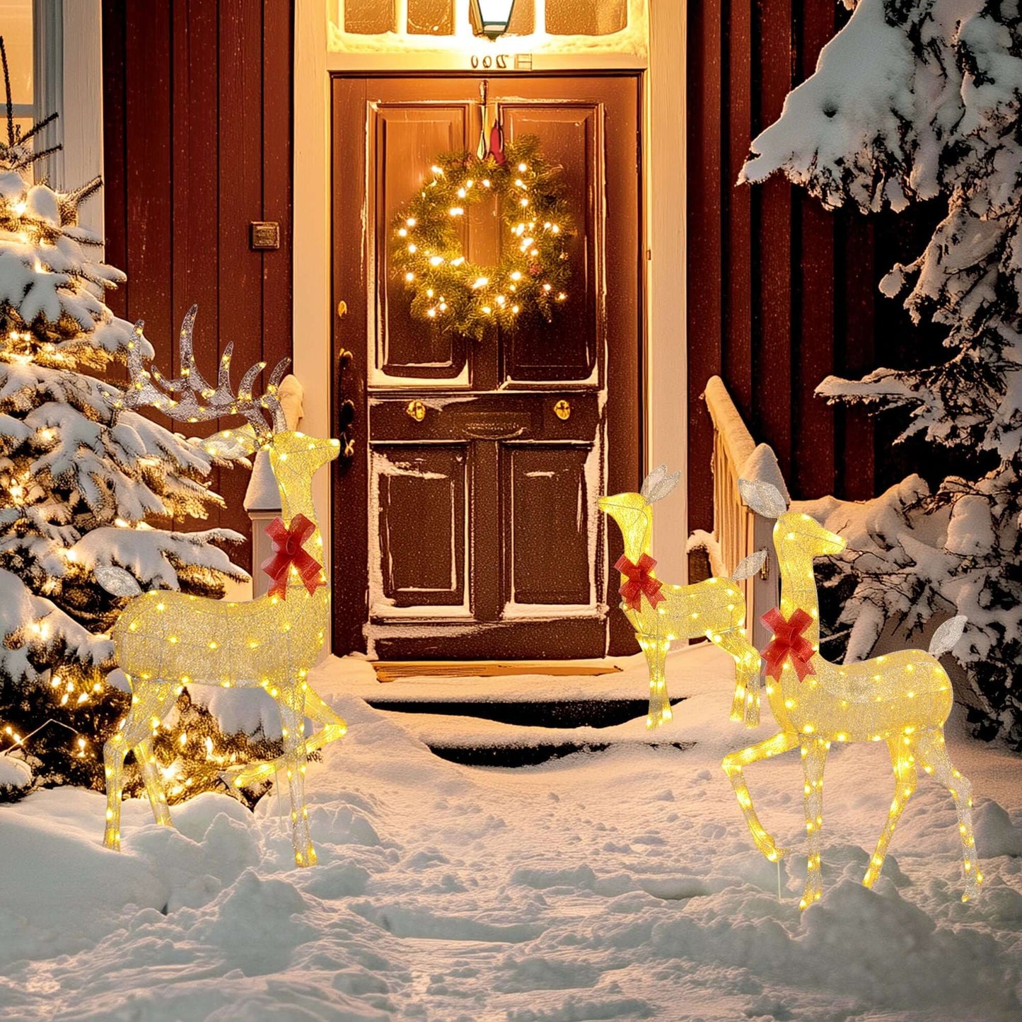 Light-up reindeer family set in snow, Christmas Deer Decorations with red bows, illuminating holiday outdoor scene at night.