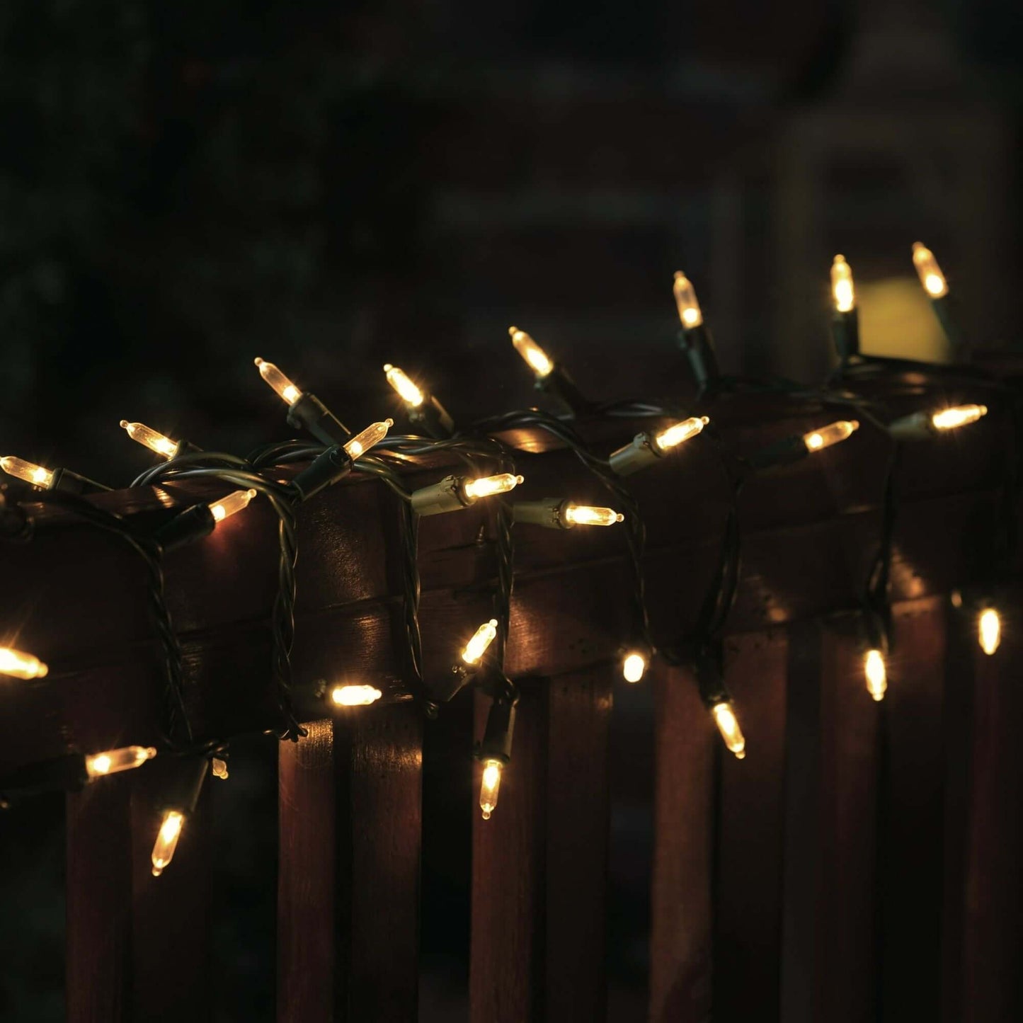 300 Count LED Mini Christmas String Lights Warm White illuminating a railing at night