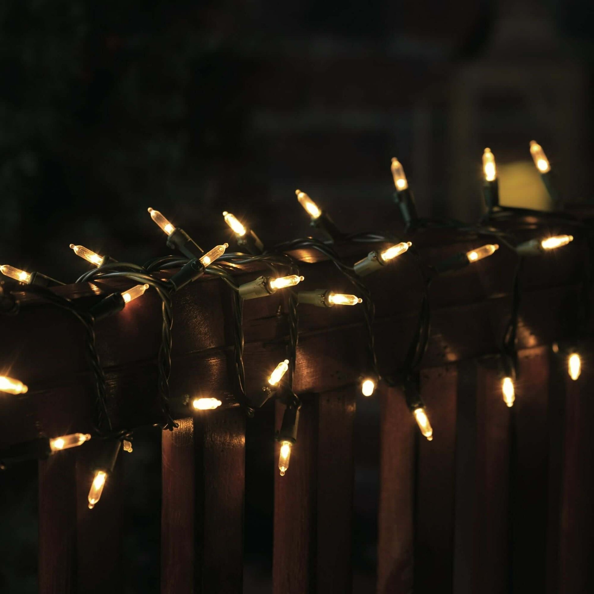 300 Count LED Mini Christmas String Lights Warm White illuminating a railing at night