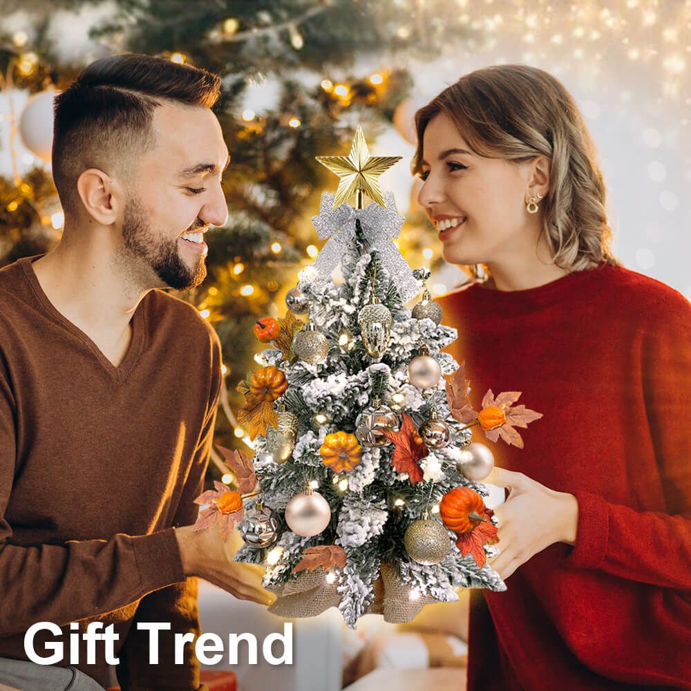 Couple with 2ft Tabletop Christmas Tree adorned with flocked snow and ornaments, perfect for fall and winter decor.