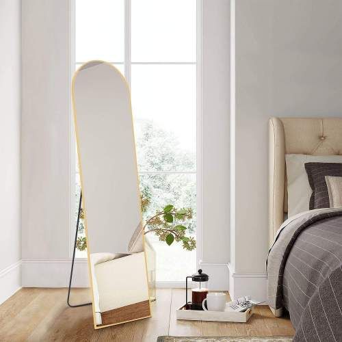 Floor standing mirror with aluminum alloy thin frame, 21x64 inches, placed in a stylish bedroom near a bed and natural light.