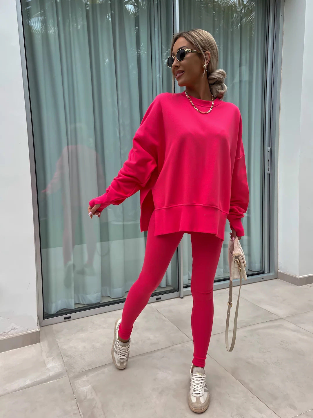 Woman wearing a bright pink Women's Casual Sweater Suit – Loose Split Top & Fitted Trousers Set, posing confidently outdoors.