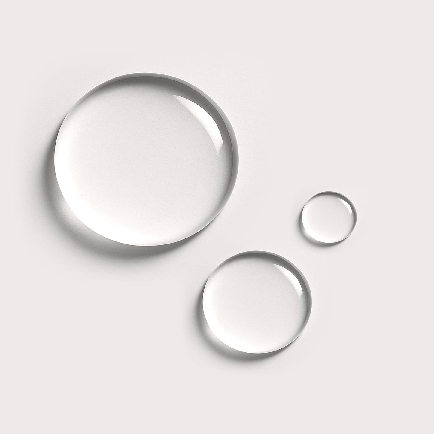 Three droplets of Makeup Remover on a white background, representing the gentle vegan formula ideal for removing makeup without stripping skin.