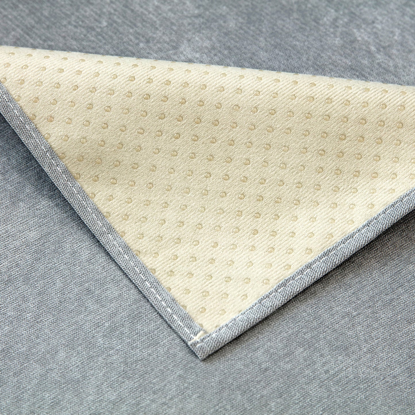 Close-up of underside texture of Waterproof Non-Slip Quilted Corduroy Sofa Covers for Pets, Sectional Couch Covers on gray fabric.