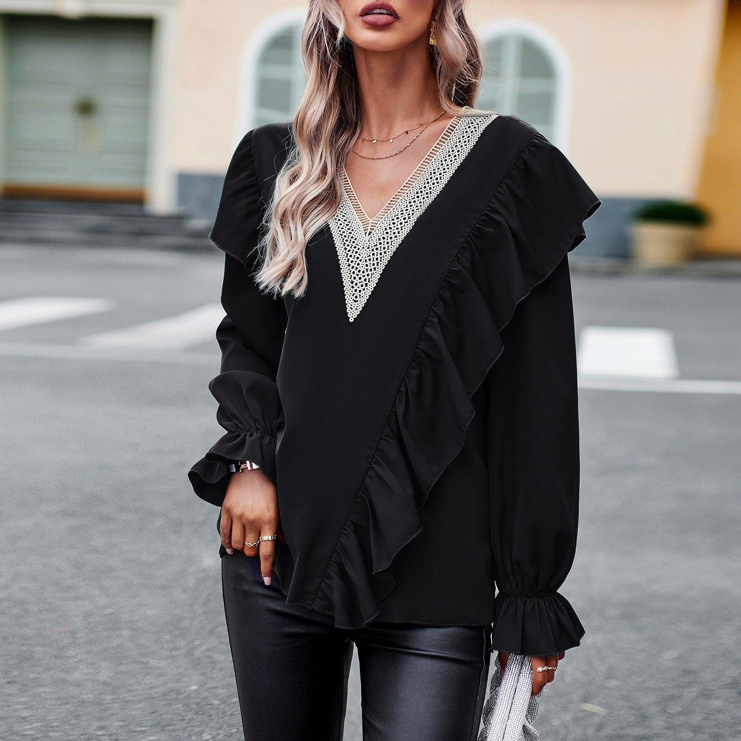 Woman wearing black Demure Commuter V-Neck Long Sleeve Shirt with elegant ruffle details.
