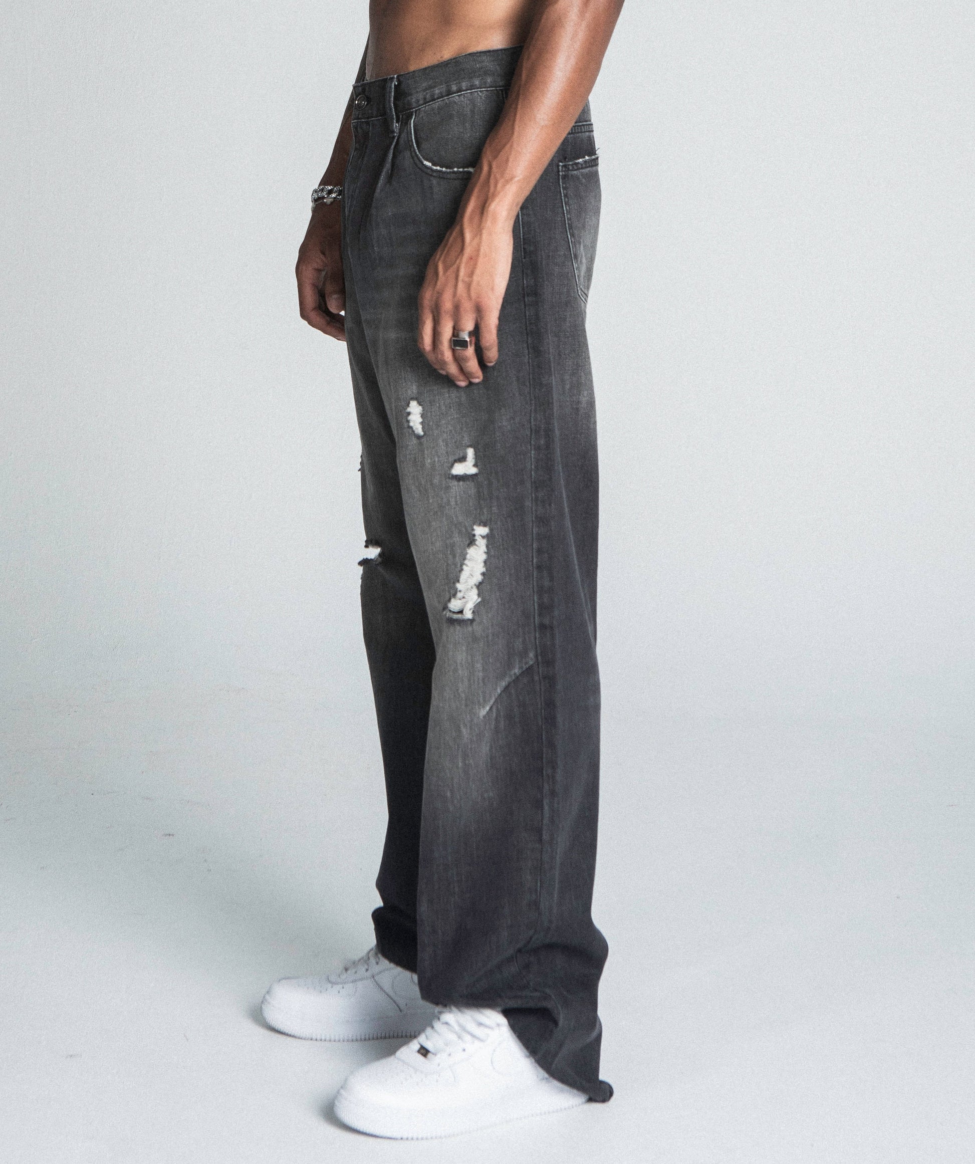 Side view of AJ09B-2 BLACK DISTRESSED BAGGY JEANS featuring mid-rise, five-pocket design, and faded cotton fabric.