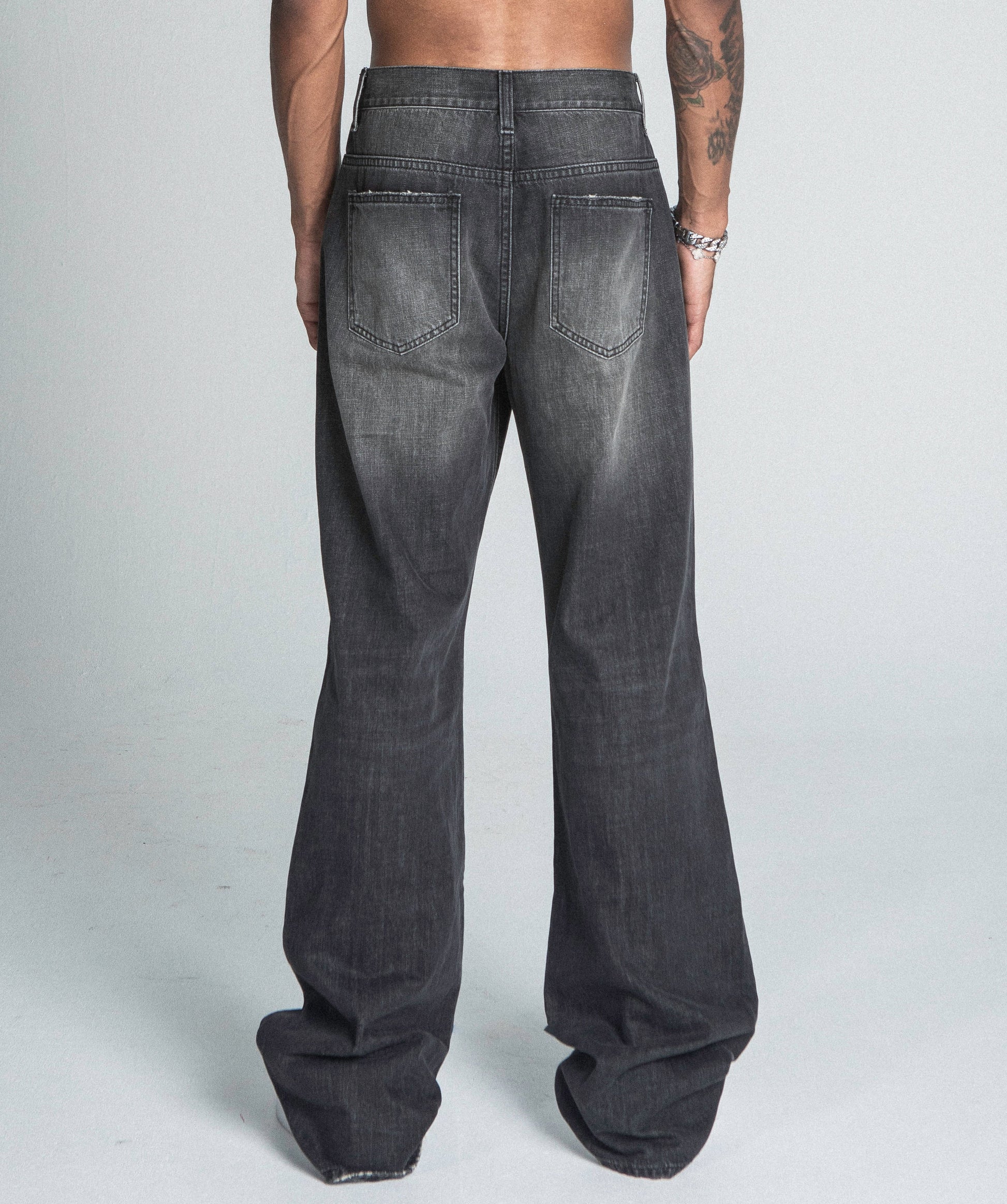 Back view of AJ09B-2 BLACK DISTRESSED BAGGY JEANS featuring faded details and a mid-rise waistband.