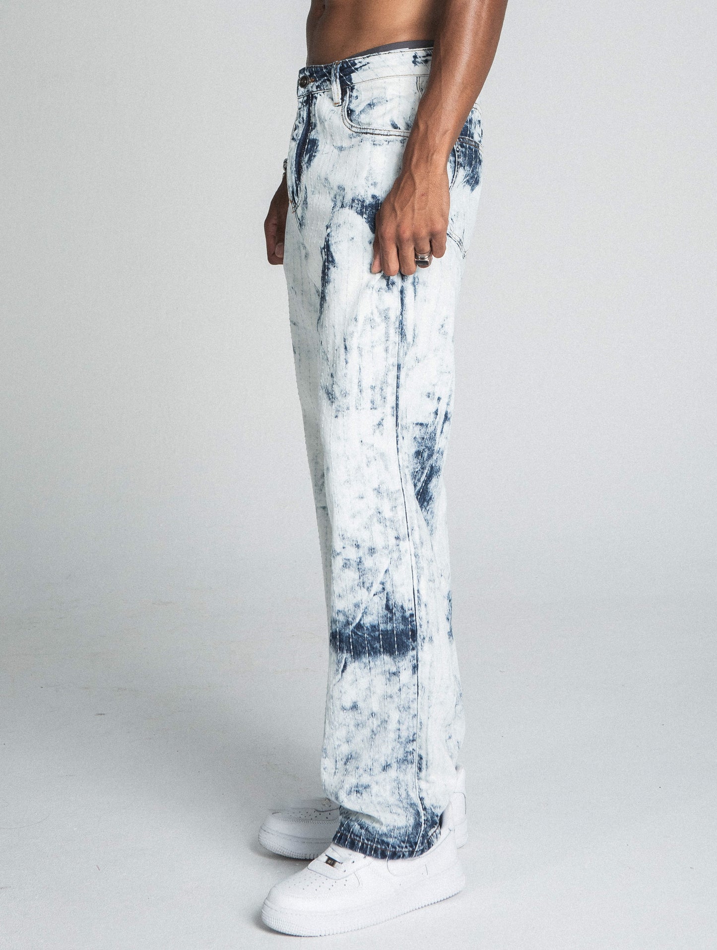 Side view of AJ01L-1 DARK BLUE/WHITE TIE DYE THREAD LINE LOOSE JEANS, mid-rise straight-leg design, worn by model with white sneakers.