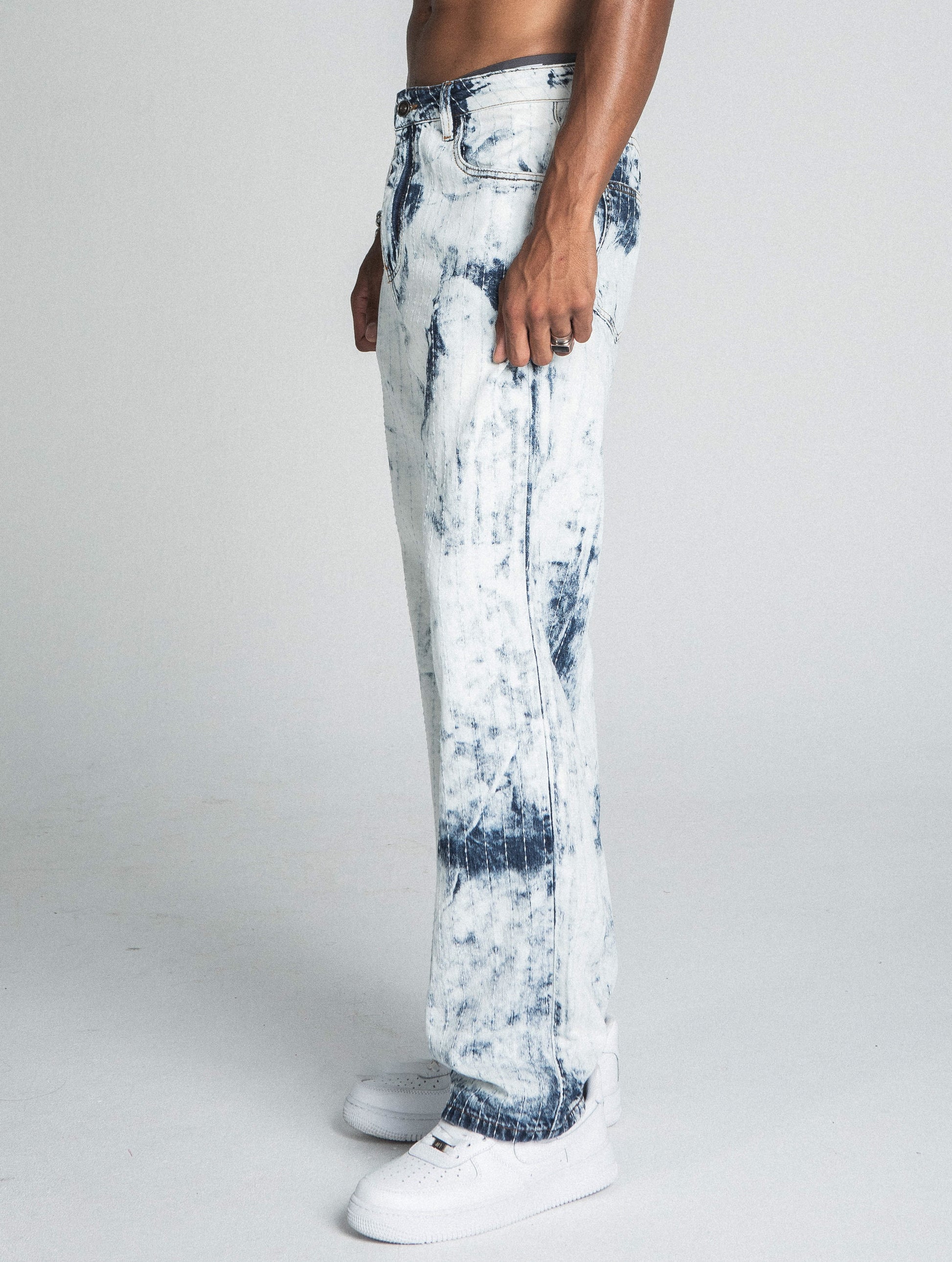 Side view of AJ01L-1 DARK BLUE/WHITE TIE DYE THREAD LINE LOOSE JEANS, mid-rise straight-leg design, worn by model with white sneakers.