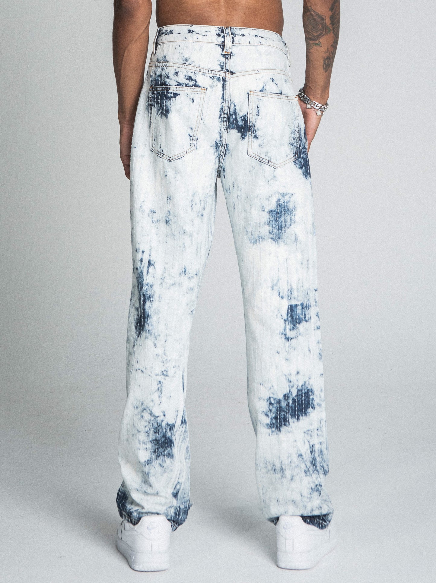 Model wearing AJ01L-1 DARK BLUE/WHITE TIE DYE THREAD LINE LOOSE JEANS showing back view, featuring a five-pocket design and belt loops.