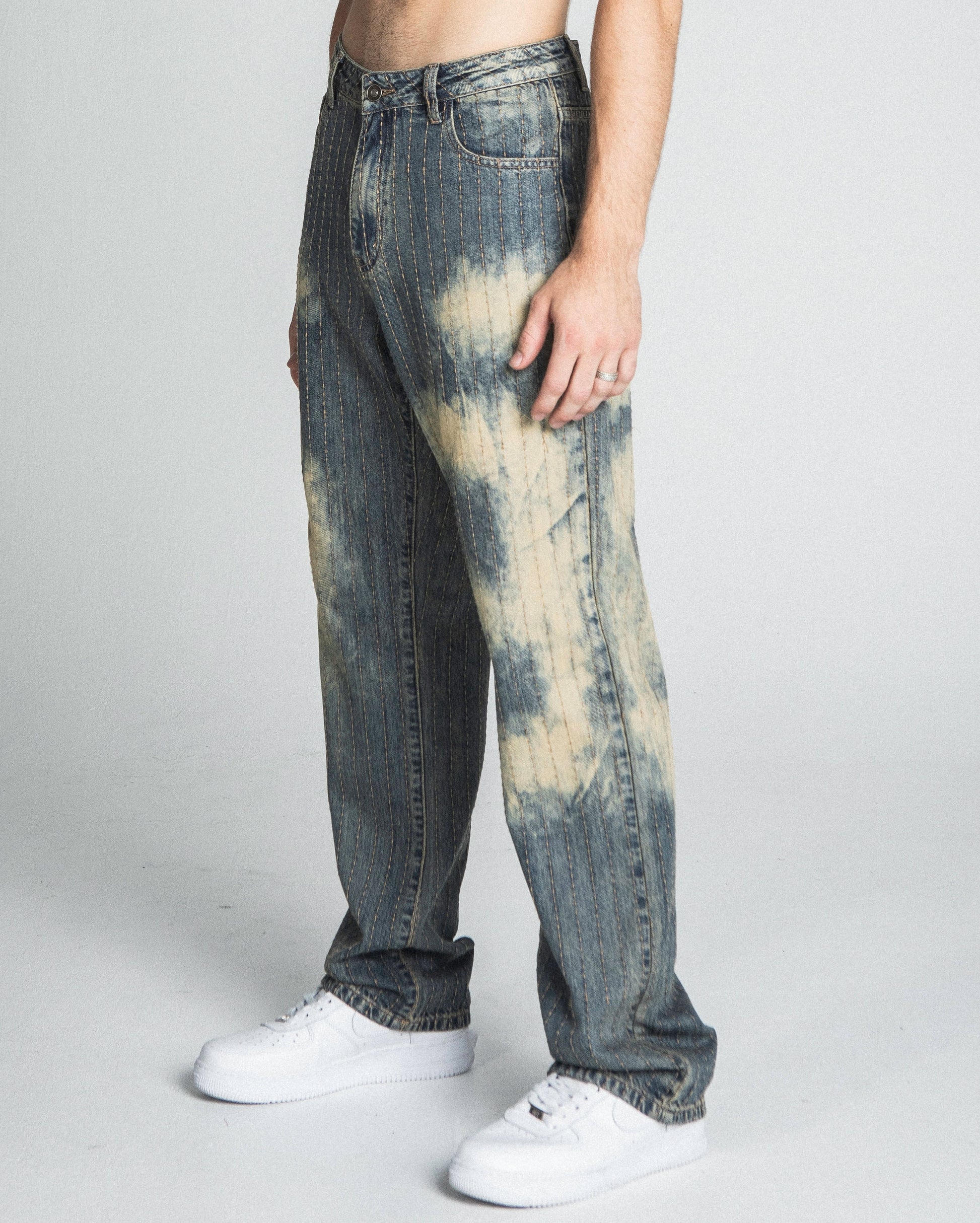 Model wearing AJ01L-3 VINTAGE THREAD LINE LOOSE JEANS, mid-rise straight-leg style, five-pocket design in tie-dye effect.