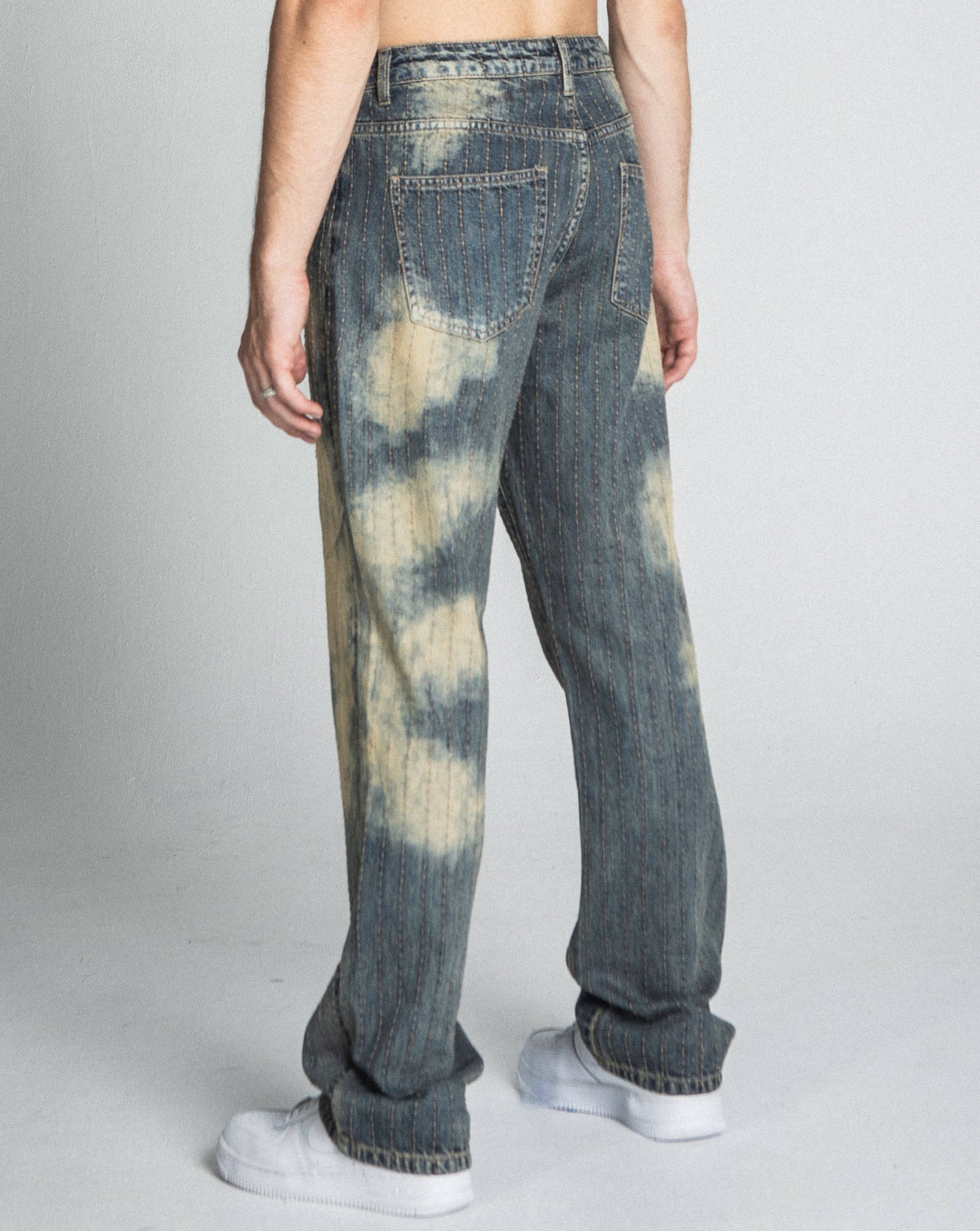 Back view of AJ01L-3 VINTAGE THREAD LINE LOOSE JEANS in blue, showcasing a mid-rise waist, five-pocket design, and unique coloration.