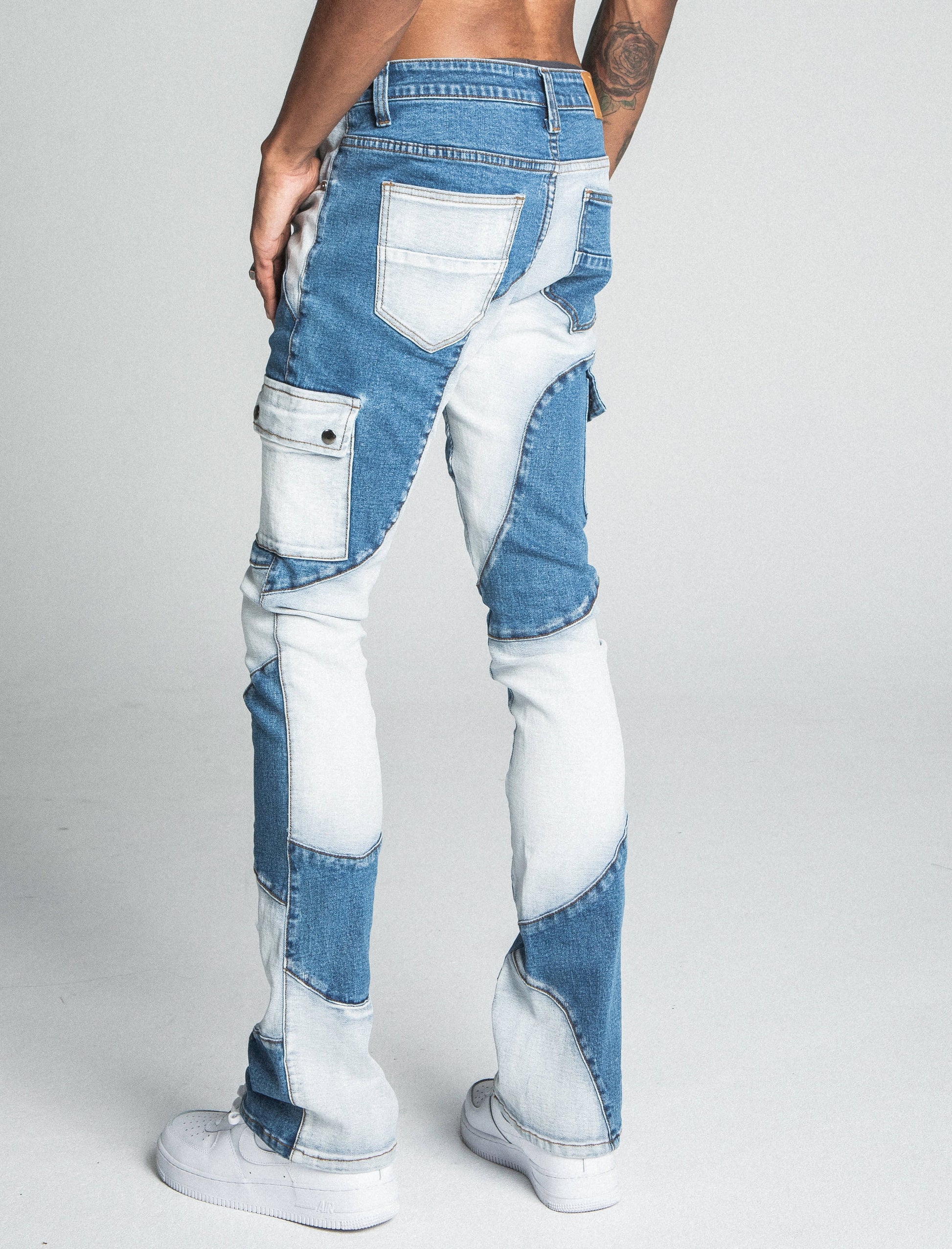 Rear view of AJ40SK COLOR BLOCK STACKED JEANS with blue and white patchwork design, mid rise waist, and five-pocket style.