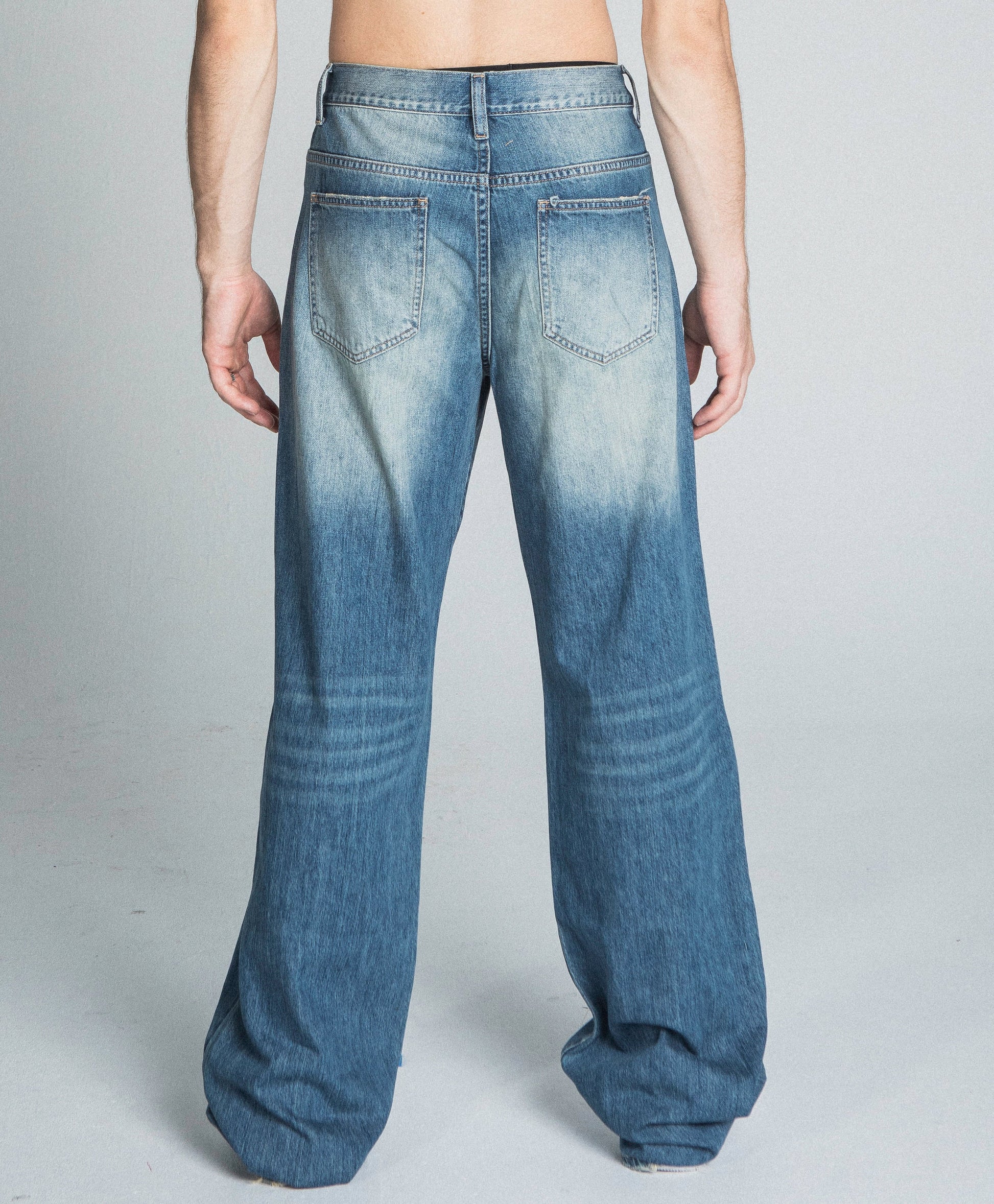 Back view of AJ09-3 CLASSIC BLUE LIGHTLY DISTRESSED BAGGY JEANS with five-pocket design and faded details.