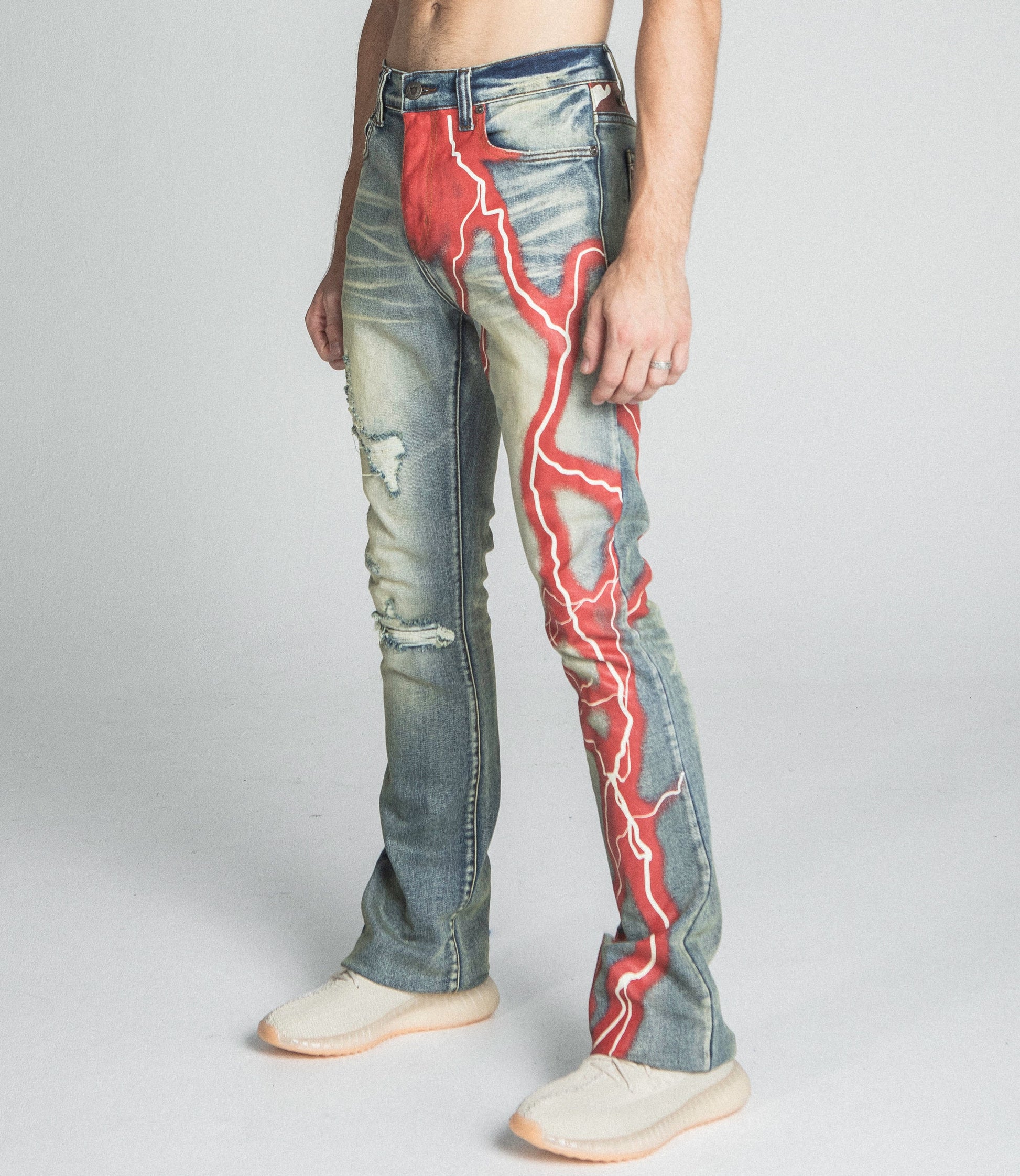 AJ24SK LIGHTNING STACKED JEANS with red lightning design, mid-rise waist, stretchy fabric, five pockets, zipper fly, and button fastening.