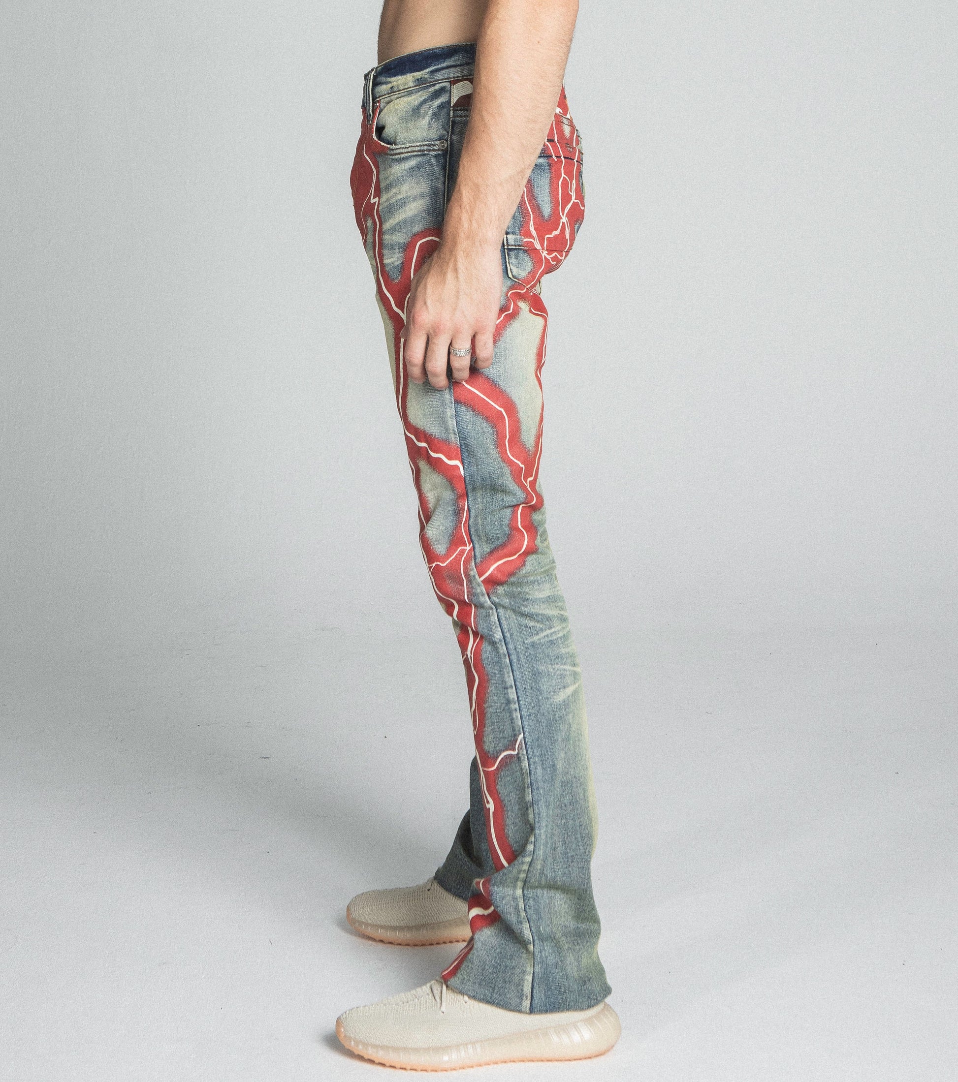 AJ24SK LIGHTNING STACKED JEANS with mid rise waist and stretchy fabric featuring a vibrant red lightning design on side profile
