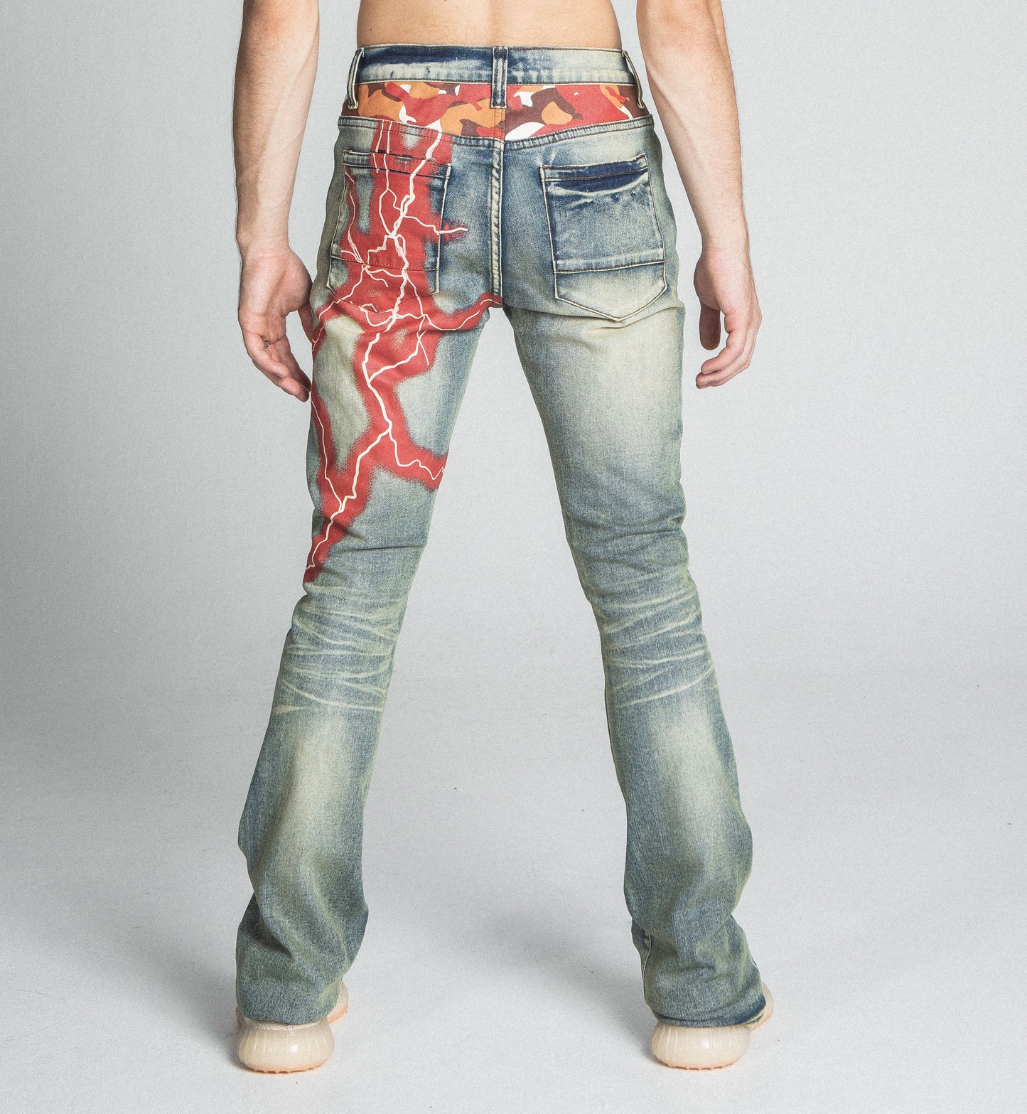 Back view of AJ24SK LIGHTNING STACKED JEANS with lightning design, showcasing mid-rise waist and five-pocket style.