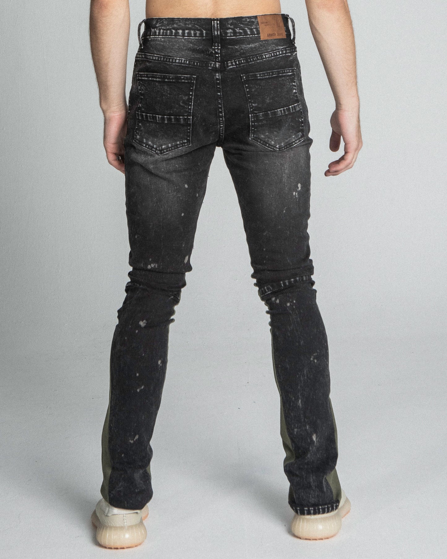 Back view of AR711 BLACK/BROWM DISTRESSED STAR STACKED JEANS with a mid-rise waist and five-pocket design, made from stretchy cotton.