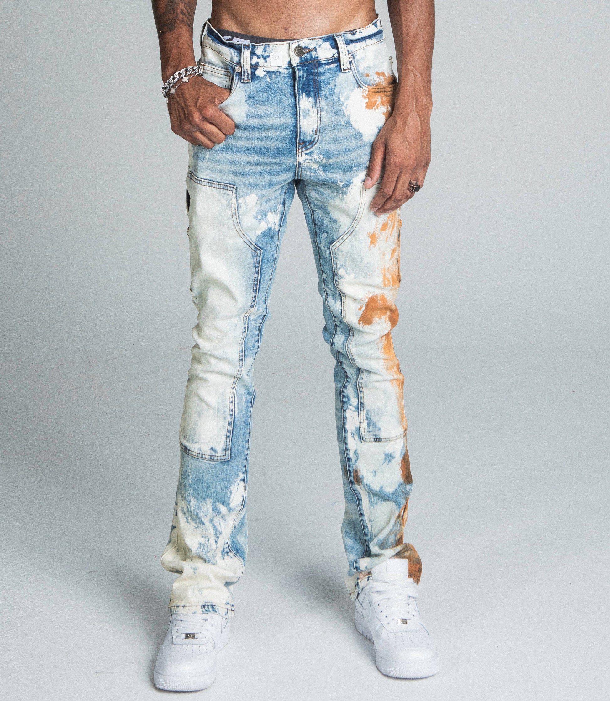 AJ19SK OIL PAINT STACKED JEANS, mid-rise stretchy jeans with oil design, cargo pockets, and zipper fly.