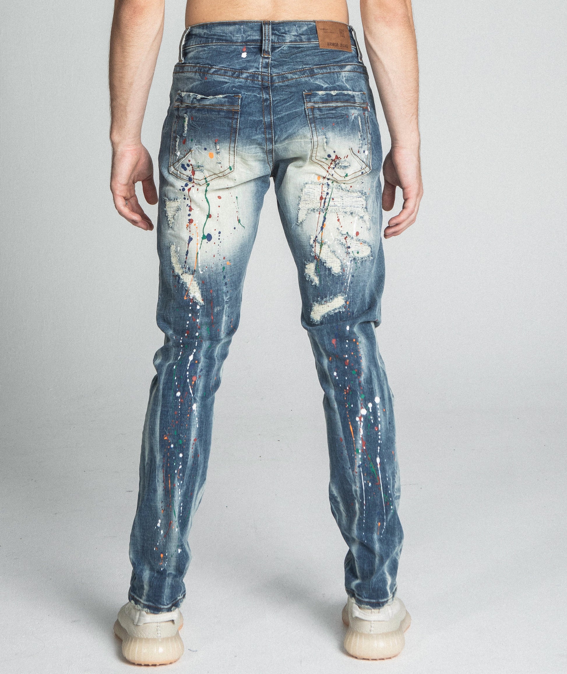 Rear view of AJ738SL-1 SPLASH PAINT VINTAGE SLIM JEANS showcasing ripped design and colorful paint splatter.