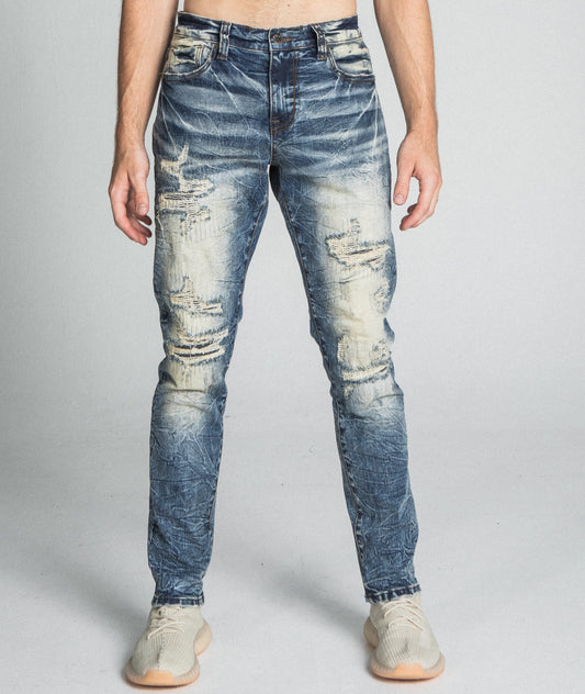 Man wearing AJ722SL-1 RIPPED VINTAGE SLIM JEANS with a stretchy, ripped design, mid-rise waist, and five pockets, made from cotton.