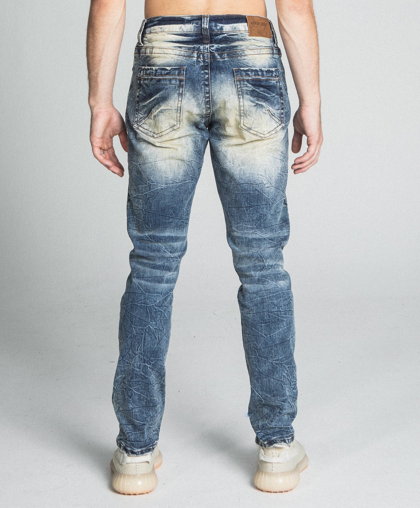 Back view of AJ722SL-1 RIPPED VINTAGE SLIM JEANS in stretchy denim with a mid-rise waist and five-pocket design on model.