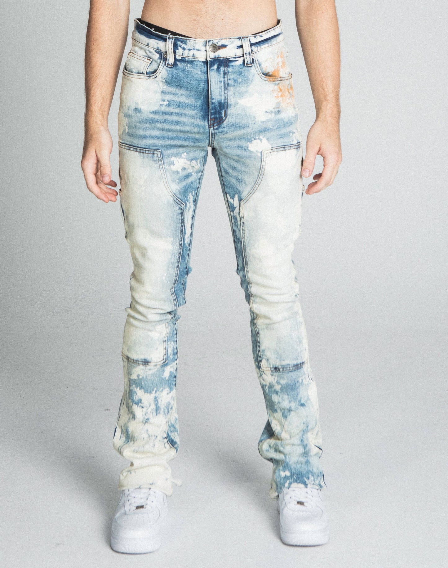 Man wearing AJ19SK OIL PAINT STACKED JEANS with oil paint design, cargo pocket, and stretchy fabric.