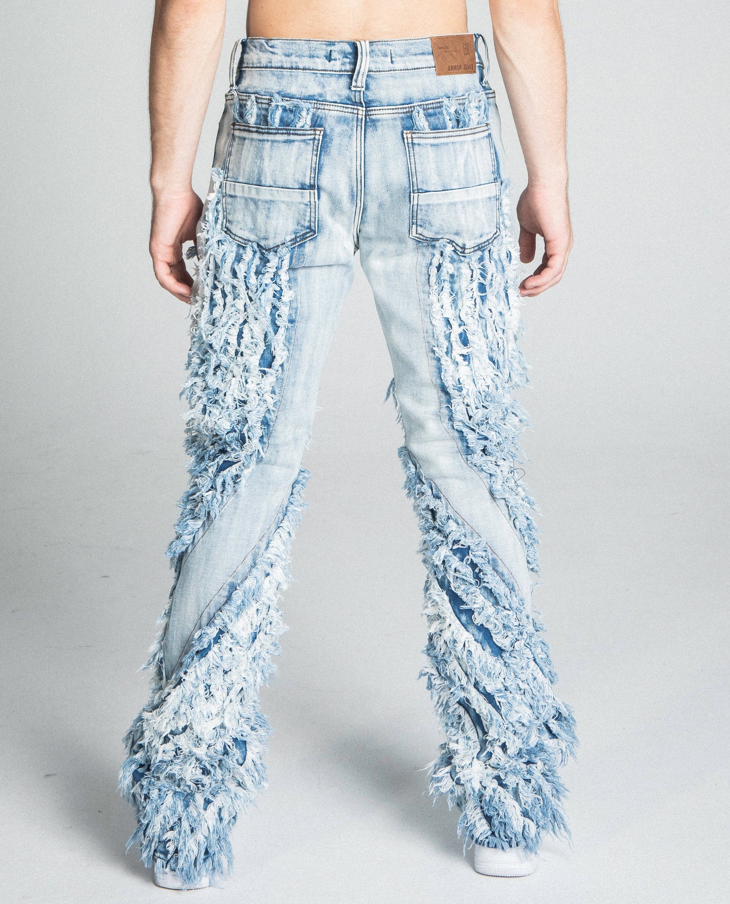 Back view of AJ18SK EXTREME FRAYED STACKED JEANS with mid rise waist and extreme frayed design in a traditional wash.