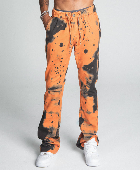 AJ04SK COLOR DYE STACKED JEANS in orange with black dye detail, featuring five-pocket design and elastic waistband, mid-rise.