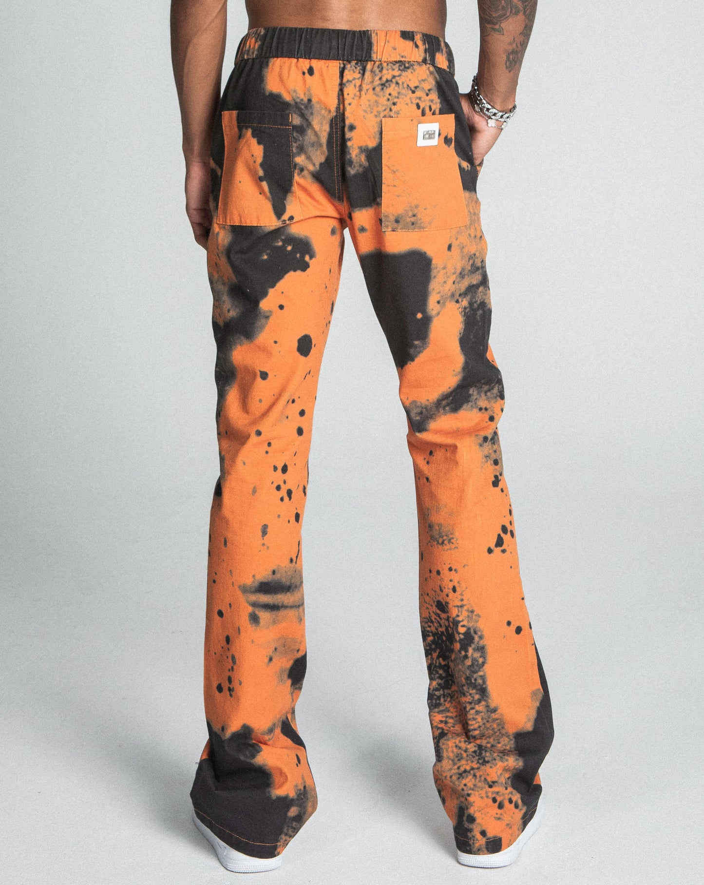 Back view of orange AJ04SK COLOR DYE STACKED JEANS featuring a color dye detail, straight-leg design, and elastic waistband.