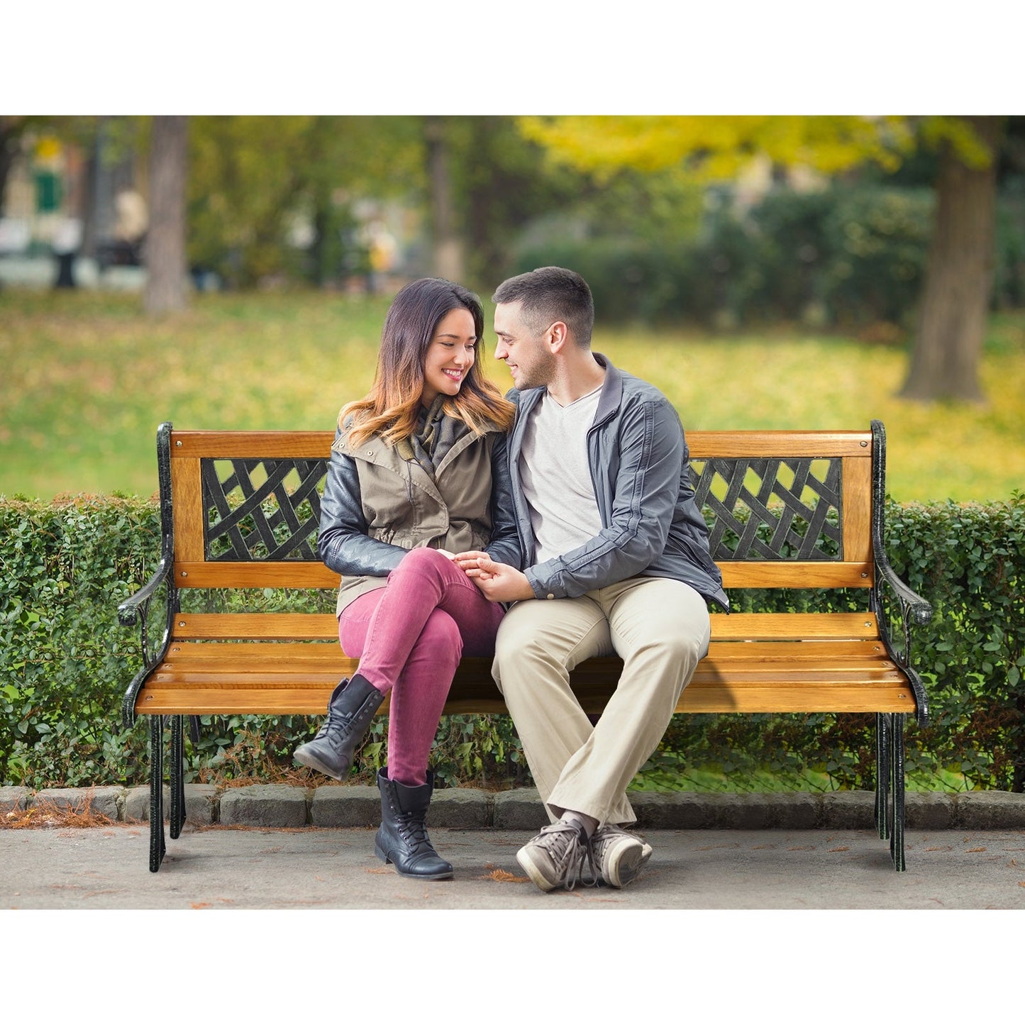 Couple sitting on an Outdoor Cast Iron Patio Bench in a park setting during fall