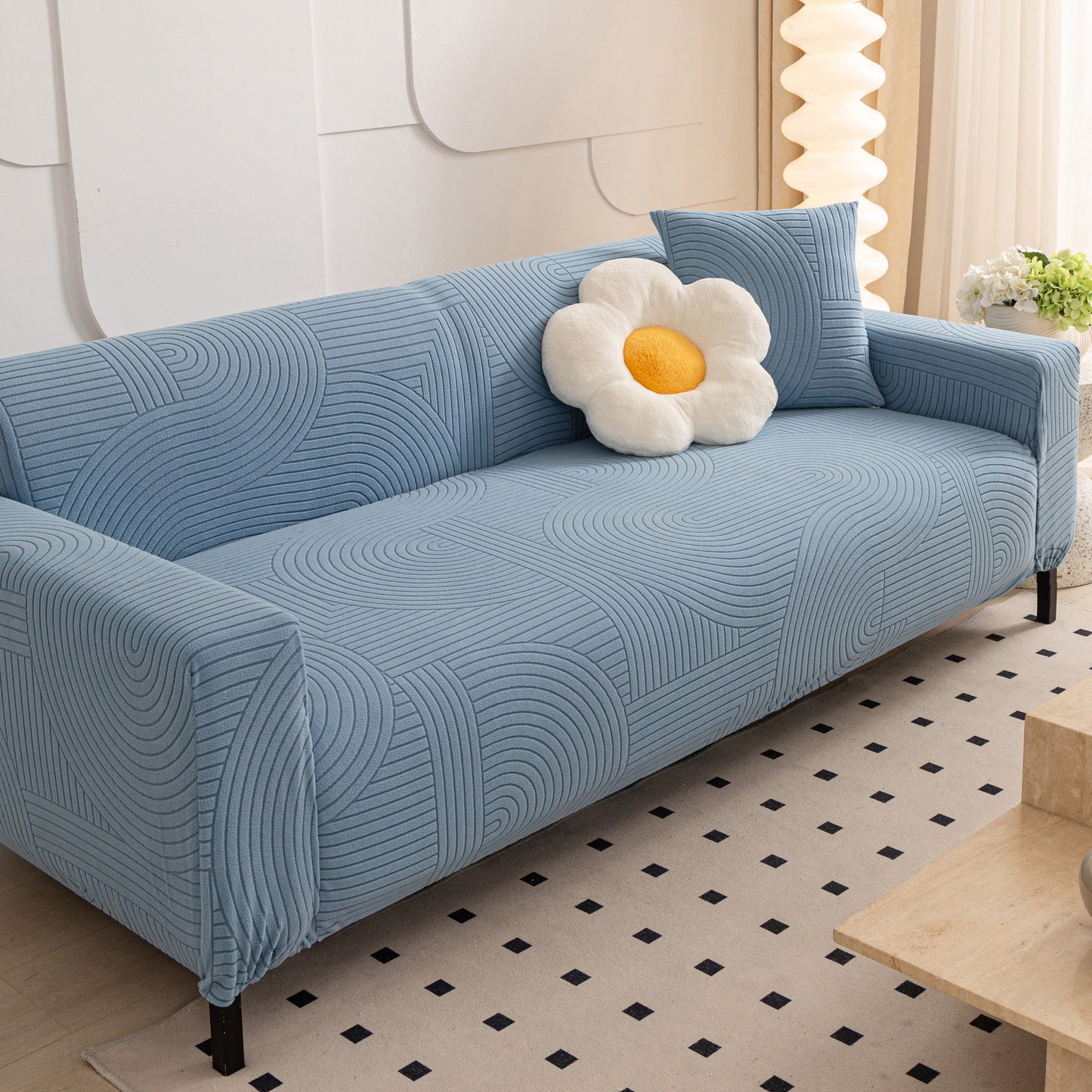 Blue sofa with geometric wave pattern covered by Fleece Stretch Sofa Slipcover Washable Soft Spandex Couch Cover Furniture Protector.