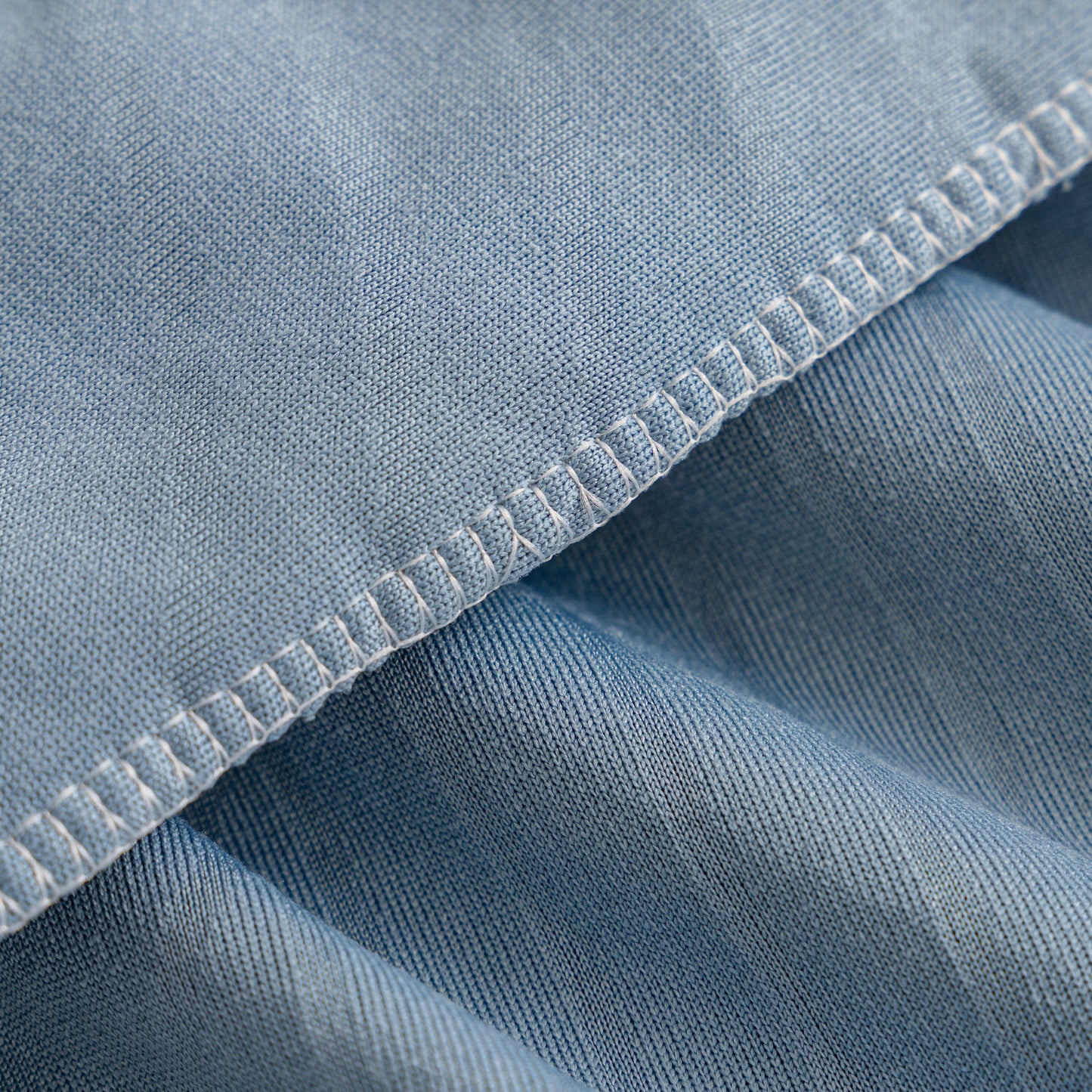 Close-up of blue Fleece Stretch Sofa Slipcover Washable Soft Spandex Couch Cover Furniture Protector, showing textured fabric detail.