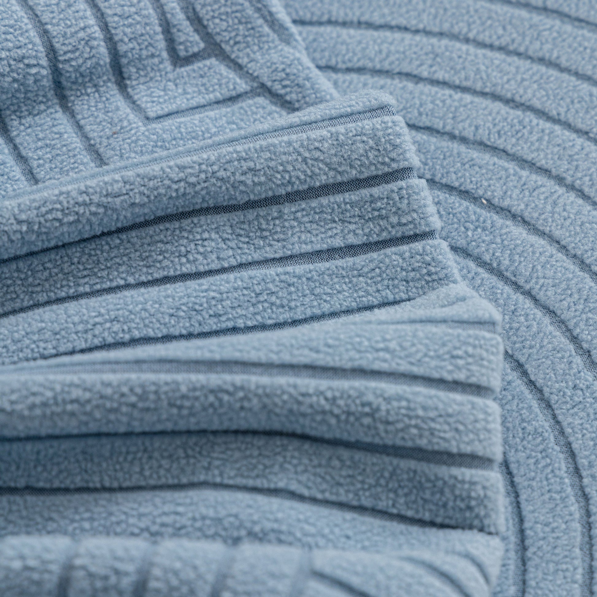 Close-up of textured Fleece Stretch Sofa Slipcover Washable Soft Spandex Couch Cover Furniture Protector in a geometric wave pattern.
