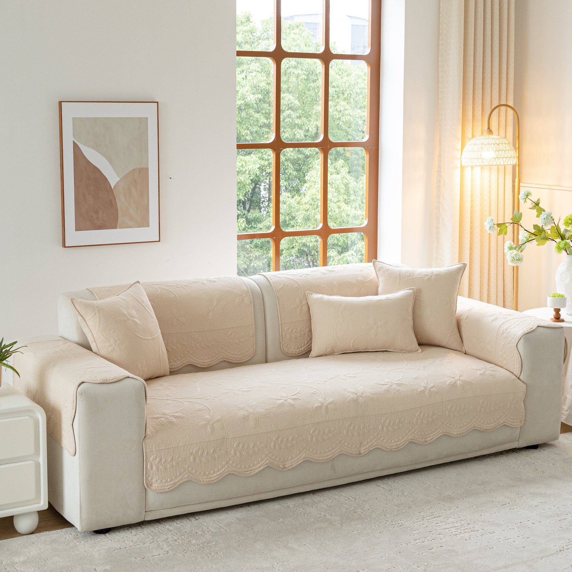 Floral Cotton Quilted Sofa Cover, Non-Slip Couch Protector with Scalloped Edges, beige cover on modern sofa enhancing living room decor.
