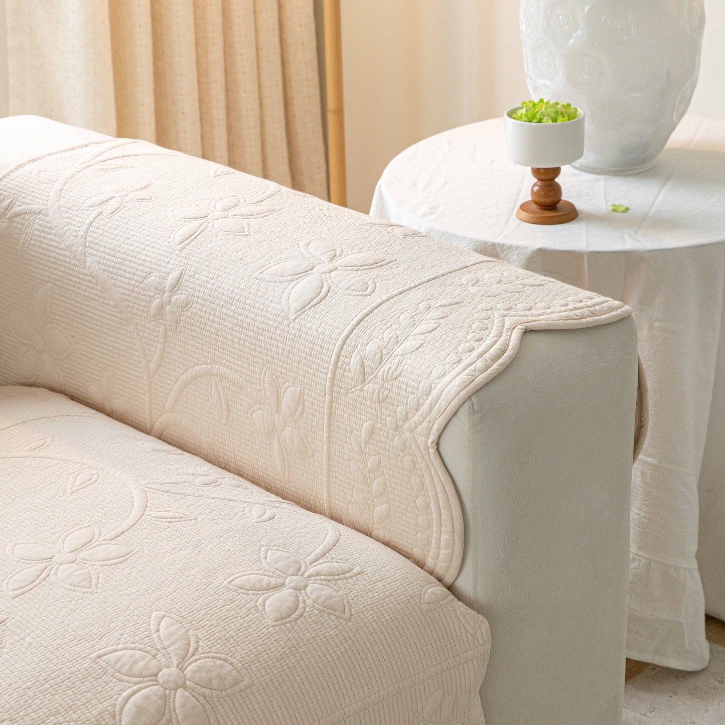 Floral Cotton Quilted Sofa Cover, Non-Slip Couch Protector with Scalloped Edges on a sofa