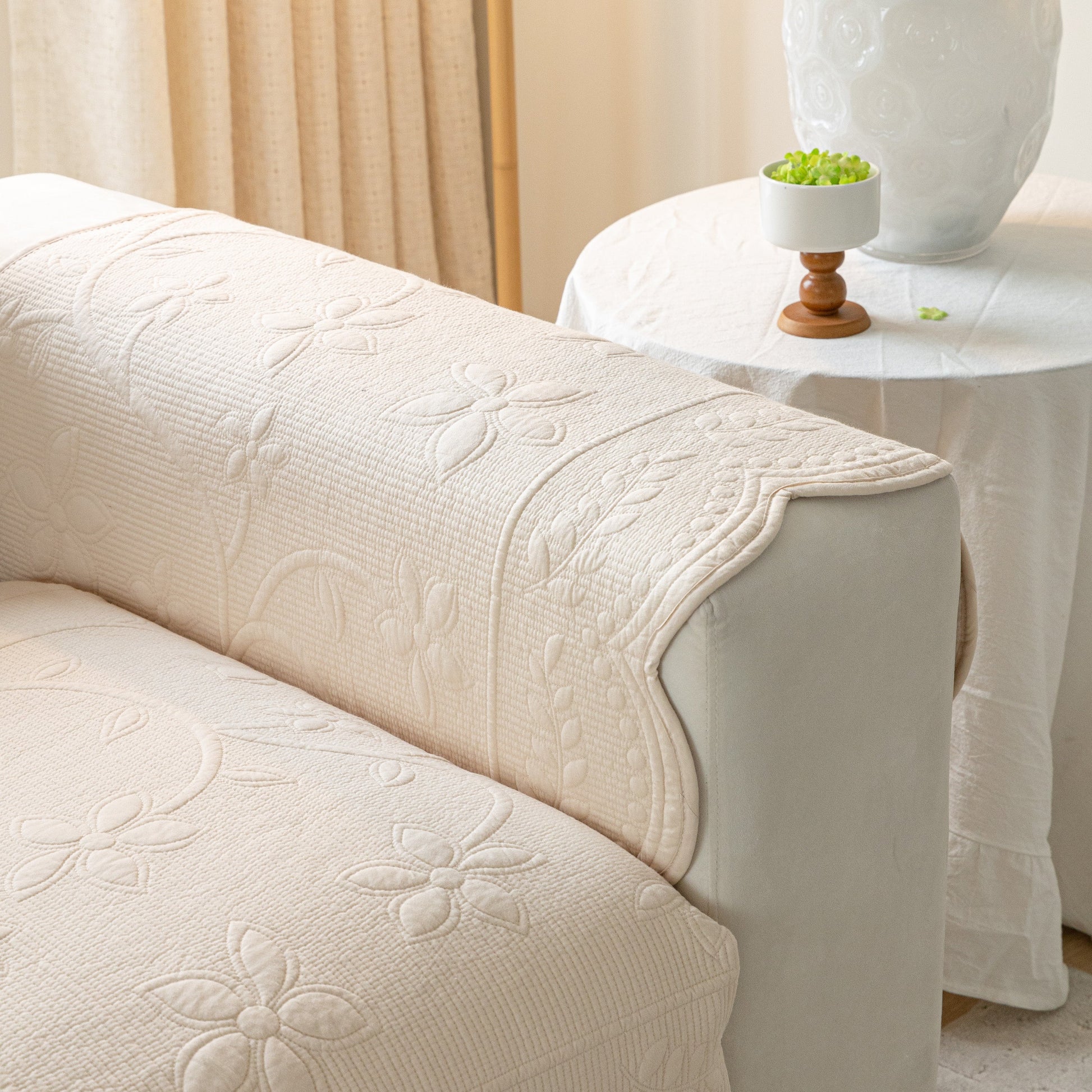 Floral Cotton Quilted Sofa Cover, Non-Slip Couch Protector with Scalloped Edges on a sofa