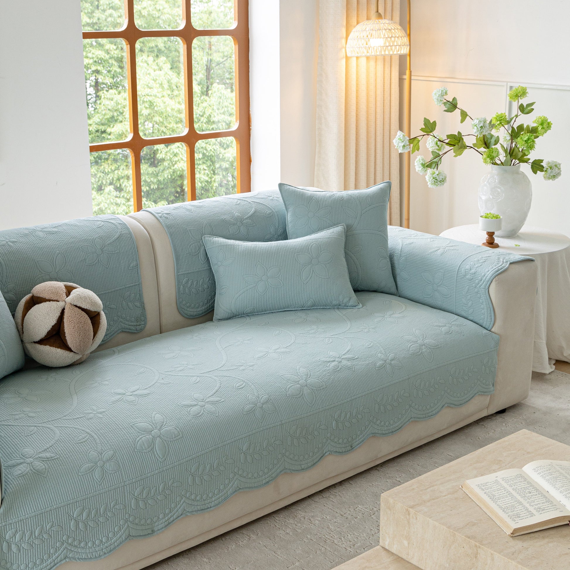 Floral Cotton Quilted Sofa Cover, Non-Slip Couch Protector with Scalloped Edges on a stylish living room sofa.