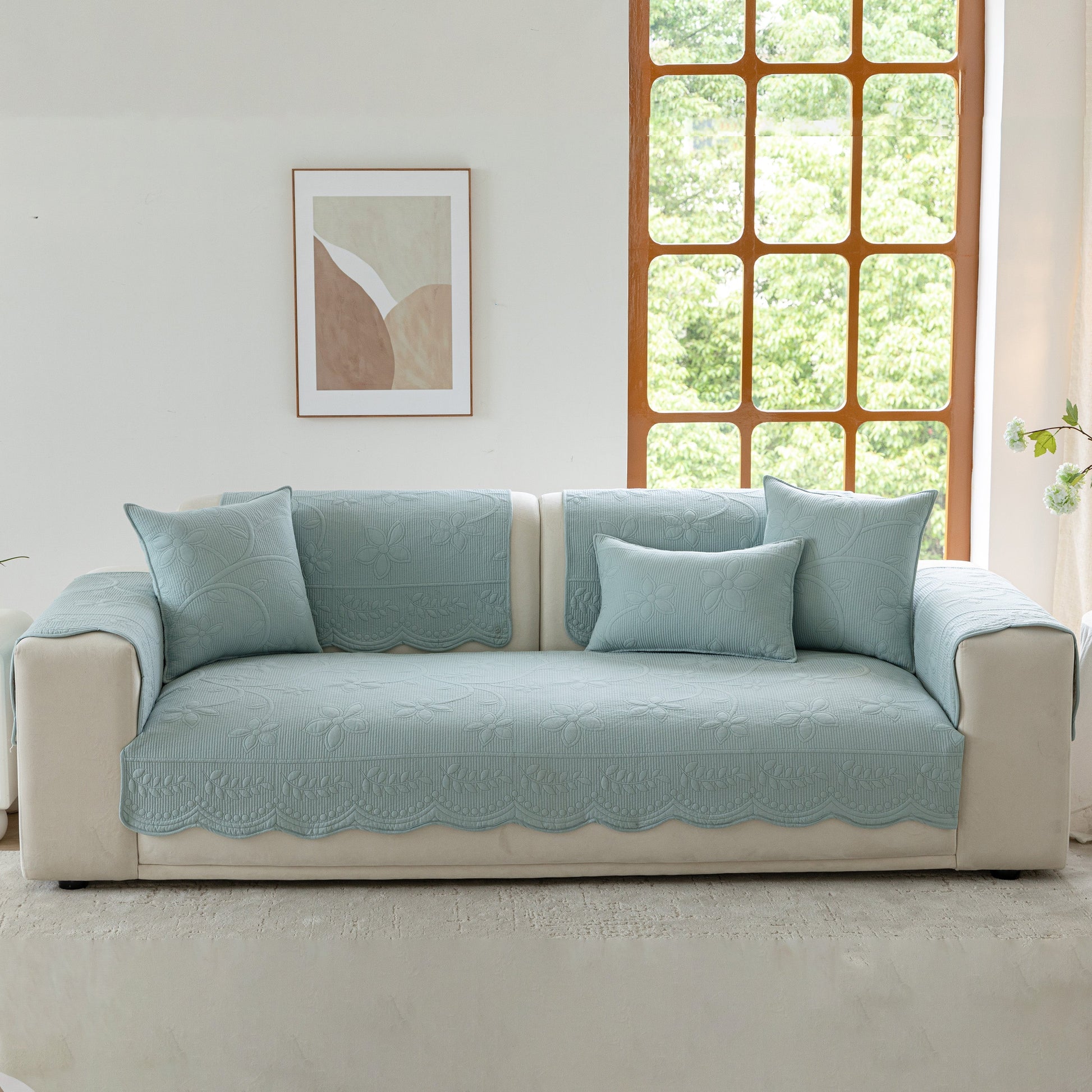 Floral Cotton Quilted Sofa Cover, Non-Slip Couch Protector with Scalloped Edges in a living room setting.