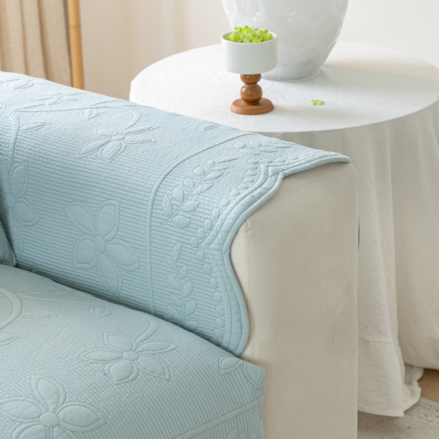 Floral Cotton Quilted Sofa Cover, Non-Slip Couch Protector with Scalloped Edges in a living room setting